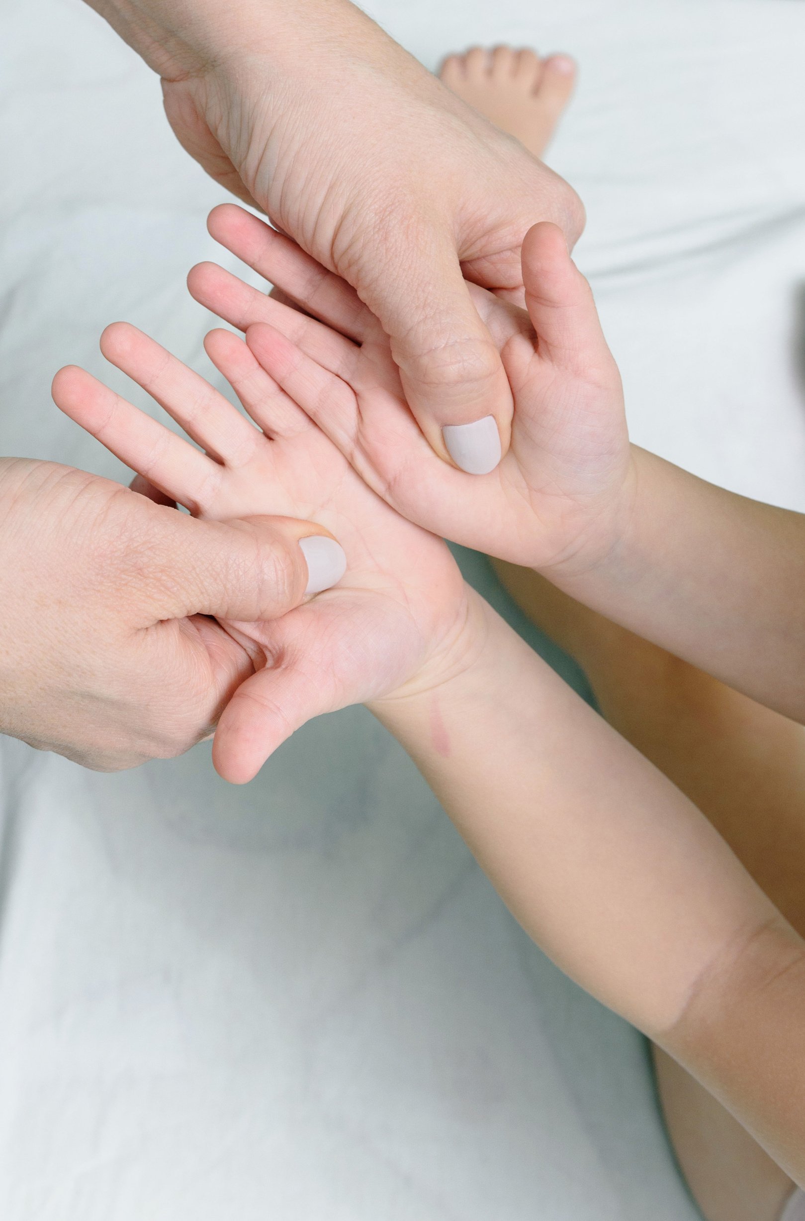 Close-Up Shot of Person Touching a Child's Hands